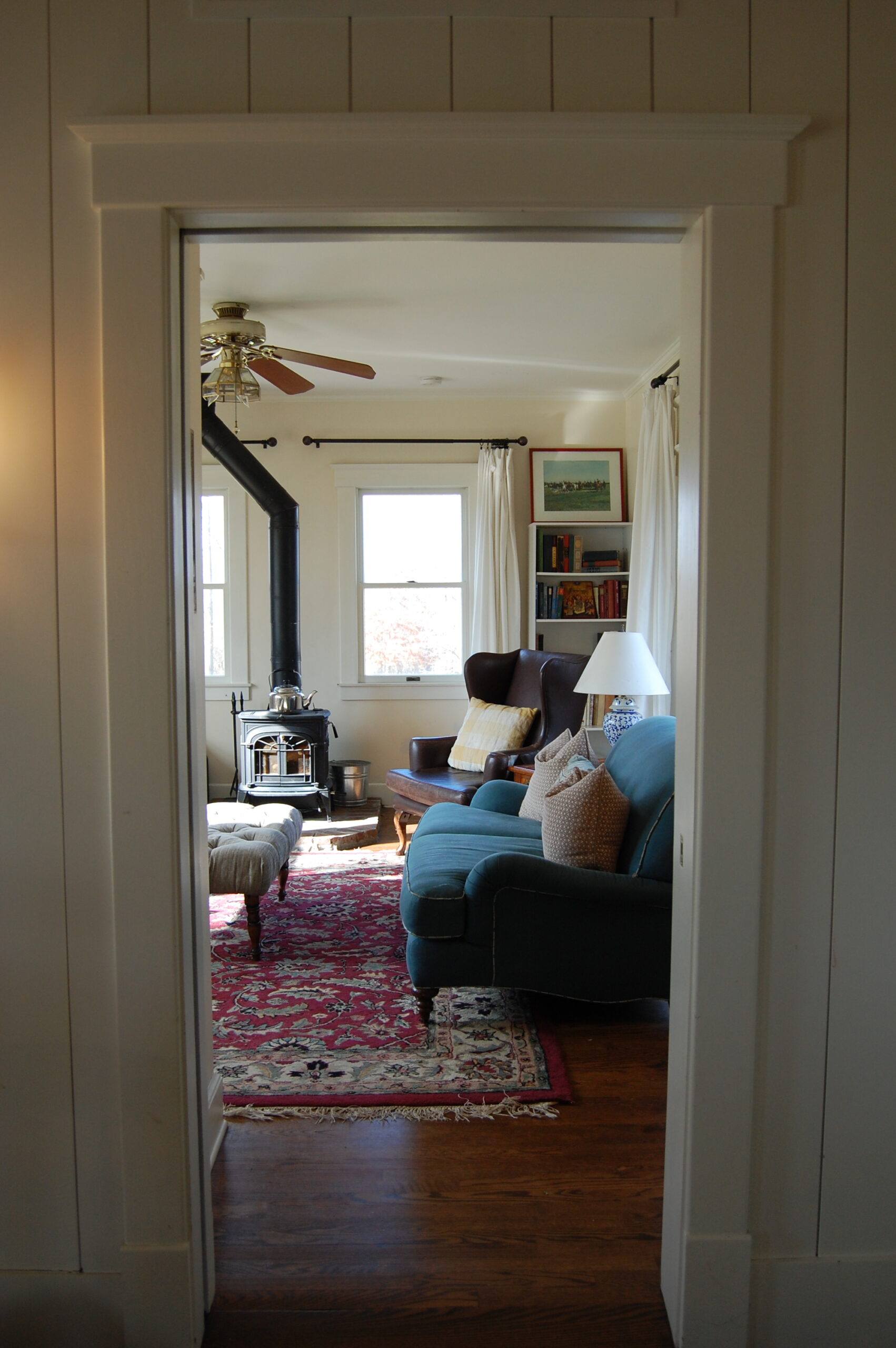 A remodeled family room with a wood-burning stove and antique furniture.